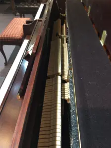 upright piano with a bench in front of it
